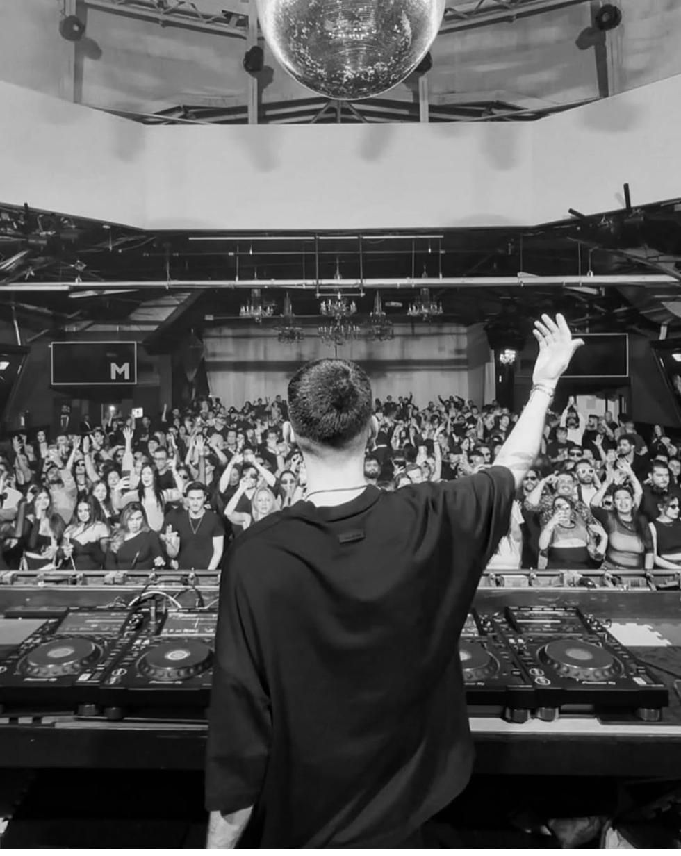 1LINE performing to a full club, one hand raised to the crowd