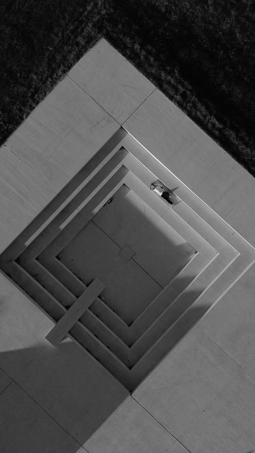 Aerial photograph of a figure standing inside concentric square steps